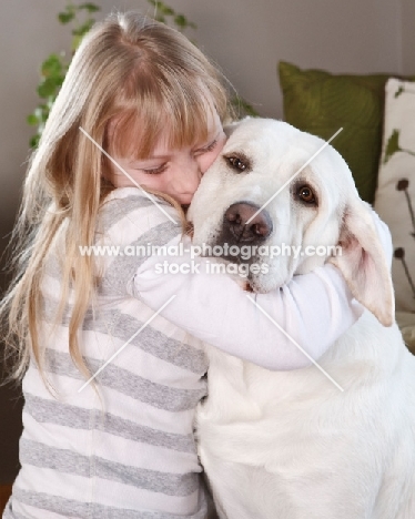 girl hugging a Labrador