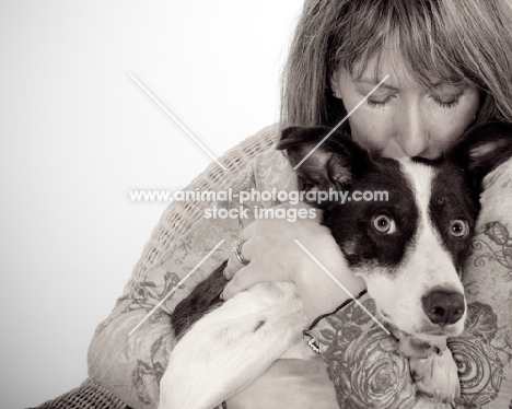 woman cuddling a border collie