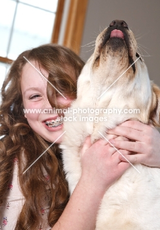 girl embraces her Labrador