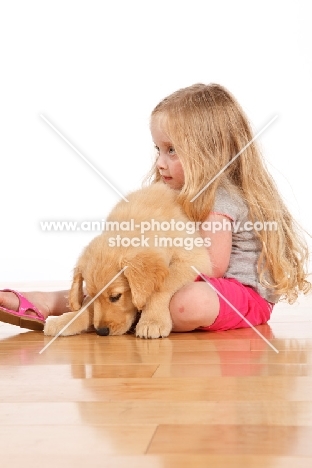 Girl and Golden Retriever puppy