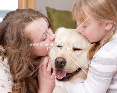 girls kissing a Labrador